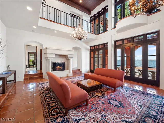 a living room with furniture a chandelier and a rug