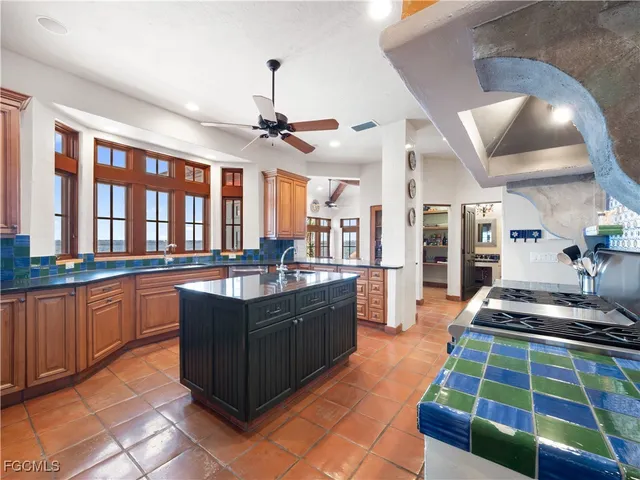 a kitchen with stainless steel appliances granite countertop a stove top oven a sink and dining table