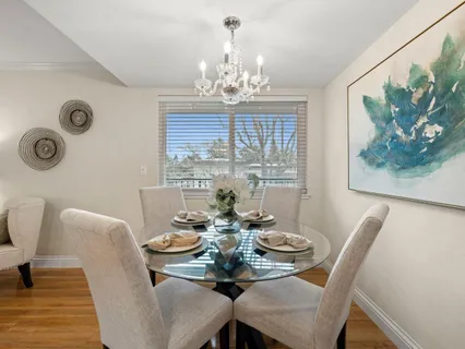 a view of a dining room with furniture a chandelier and wooden floor