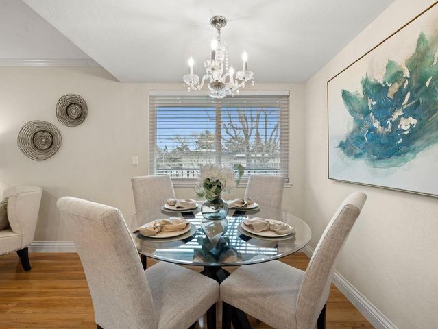 a view of a dining room with furniture a chandelier and wooden floor