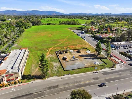 an aerial view of a residential houses with outdoor space and street view
