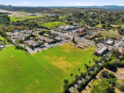 an aerial view of residential houses with outdoor space and trees