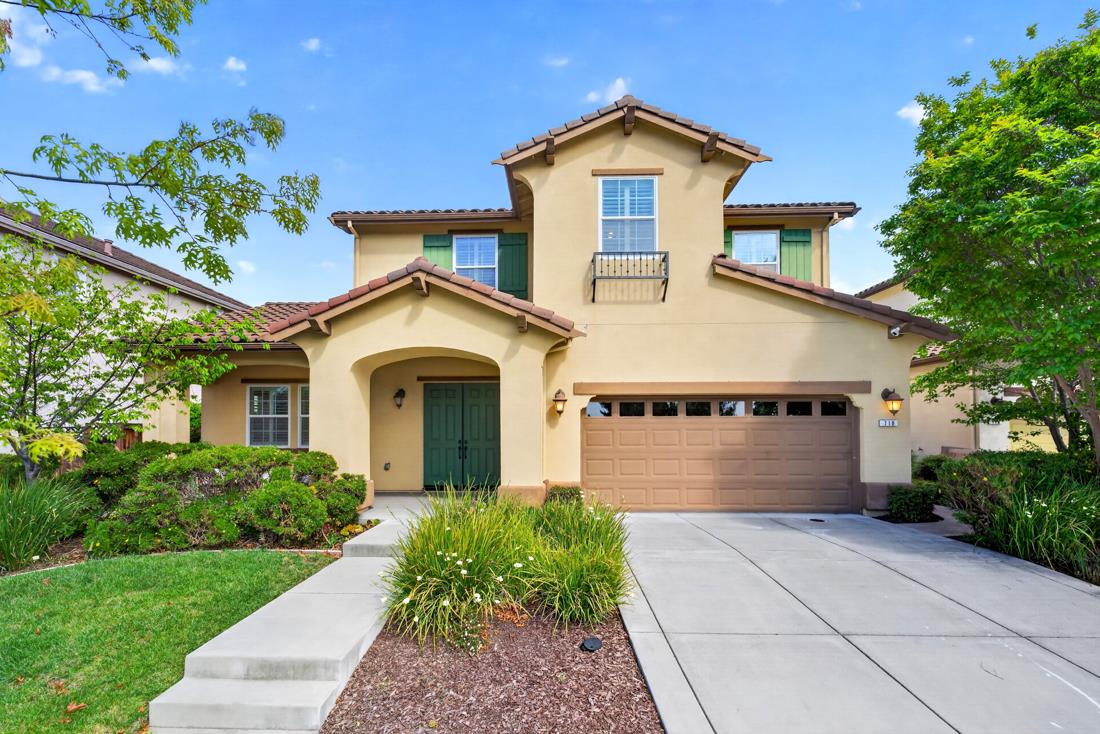 a view of a house with a yard and potted plants