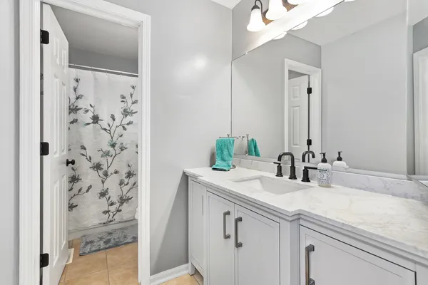 a bathroom with a granite countertop sink and a mirror