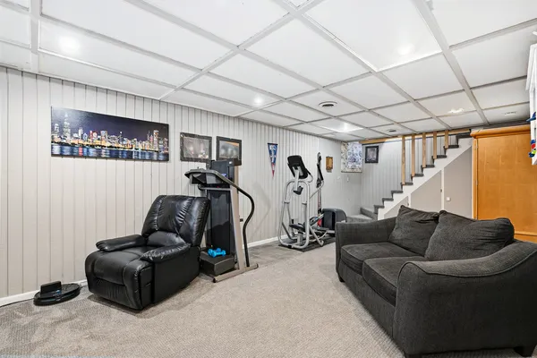 a living room with furniture and a gym machine
