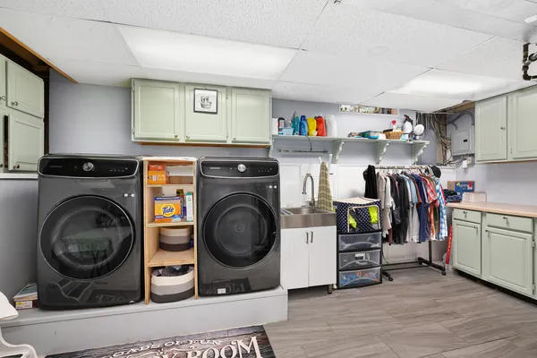 a utility room with sink dryer and washer