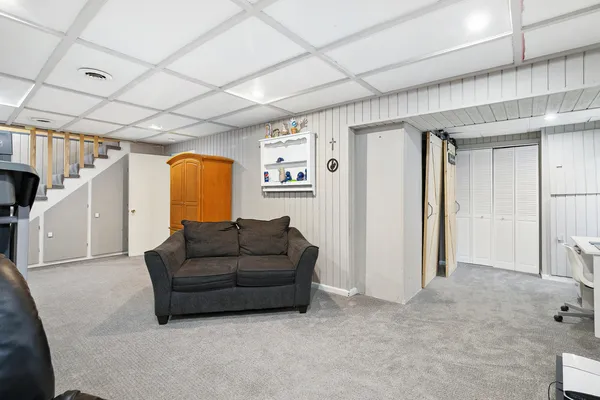 a living room with furniture and a open kitchen