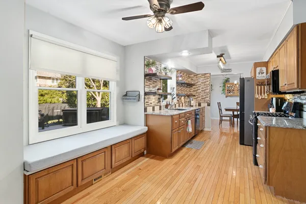 a kitchen with stainless steel appliances kitchen island wooden floors and center island