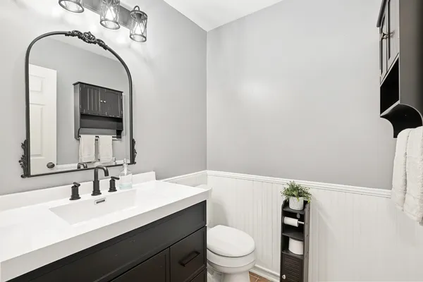 a bathroom with a toilet a sink and mirror