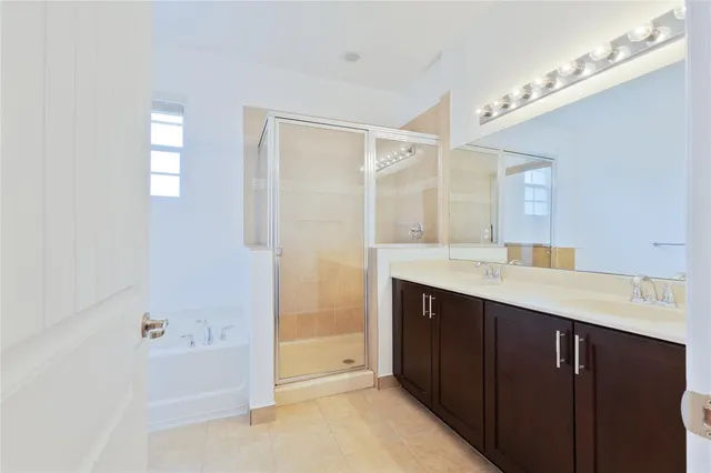 a bathroom with a tub a sink and mirror