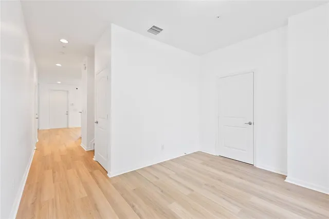 a view of a room with wooden floor and white walls