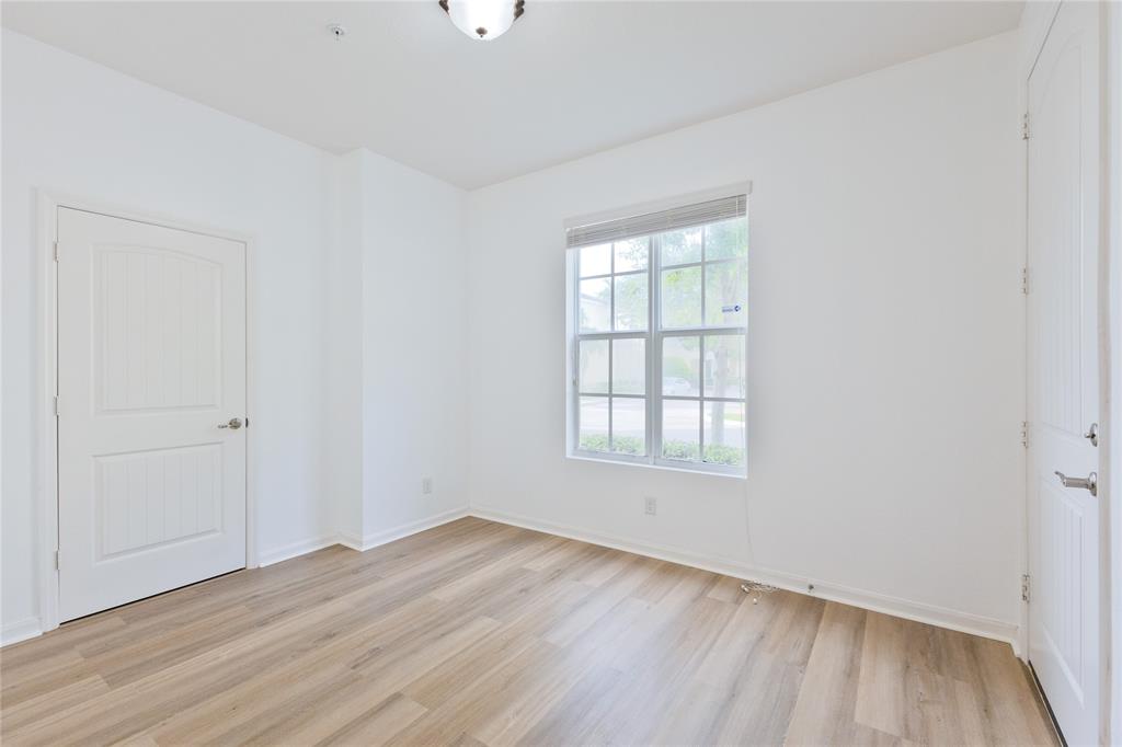 122 Southwest 7th Court, Unit 122 Pompano Beach, FL 33060 - Photo 14 of 36 an empty room with wooden floor and windows