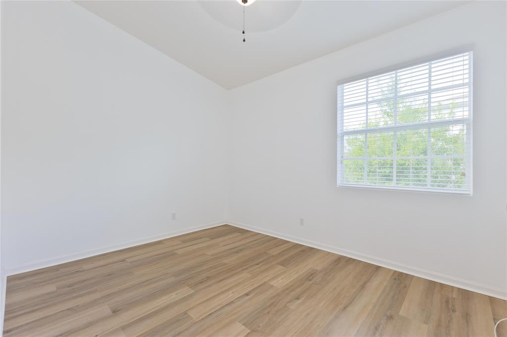 122 Southwest 7th Court, Unit 122 Pompano Beach, FL 33060 - Photo 22 of 36 an empty room with wooden floor and windows
