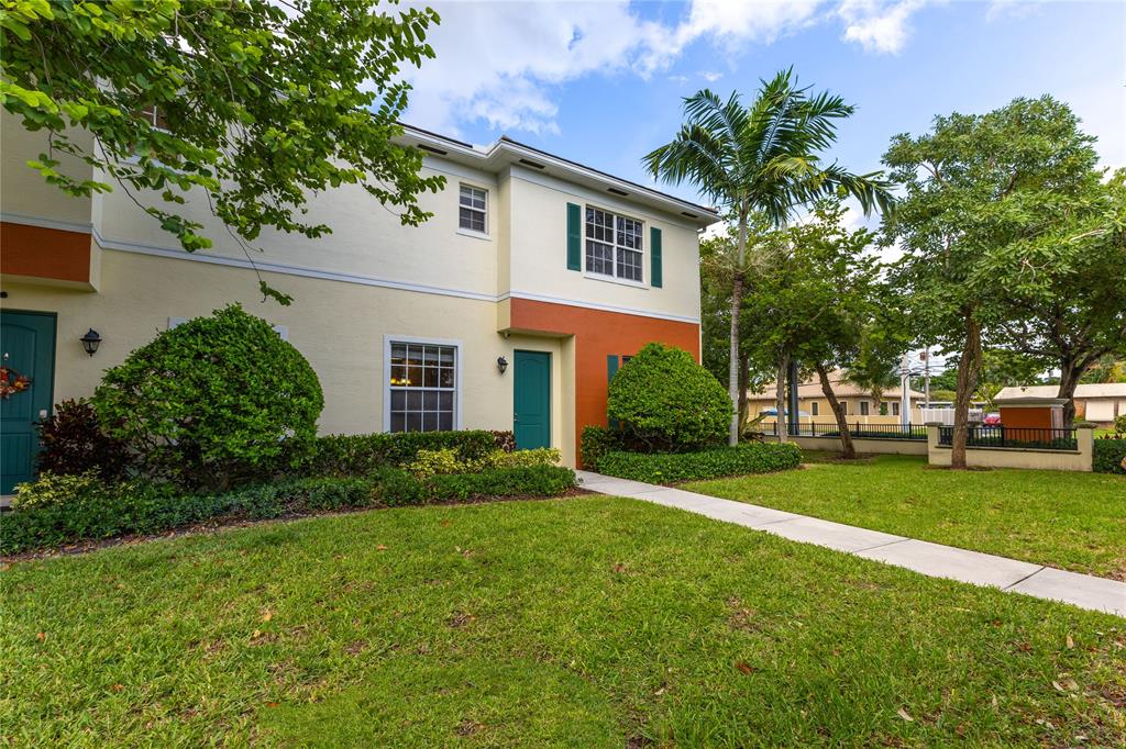 122 Southwest 7th Court, Unit 122 Pompano Beach, FL 33060 - Photo 30 of 36 a view of a white house next to a yard with big trees