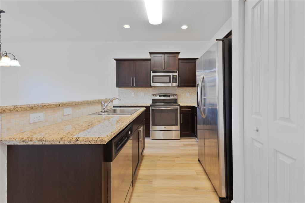 122 Southwest 7th Court, Unit 122 Pompano Beach, FL 33060 - Photo 5 of 36 a kitchen with kitchen island granite countertop stainless steel appliances stove a sink and a refrigerator