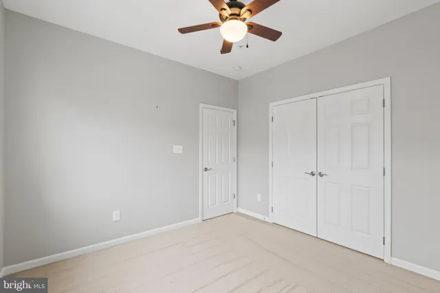 a view of an empty room and chandelier fan