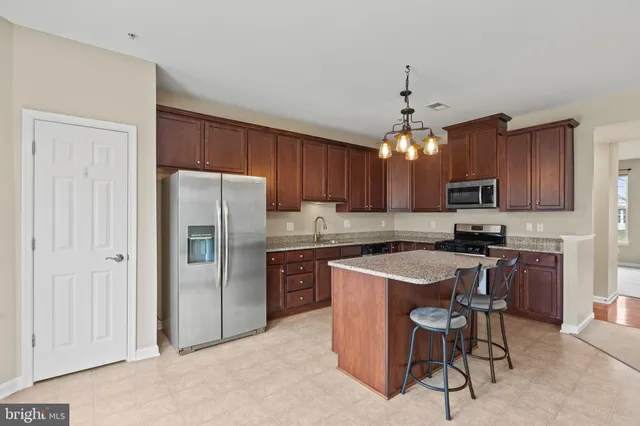 a kitchen with stainless steel appliances granite countertop a refrigerator stove a sink and dishwasher