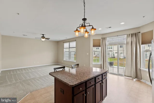 a view of a kitchen with granite countertop a sink stainless steel appliances and cabinets