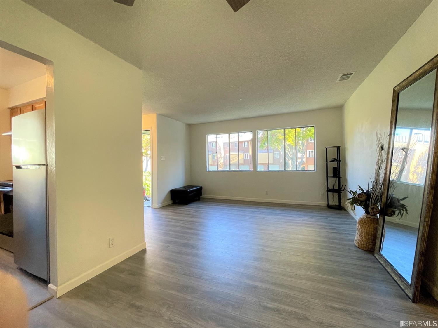 1493 Del Rio Circle, Unit D Concord, CA 94518 - Photo 6 of 23 a view of empty room with wooden floor and fan