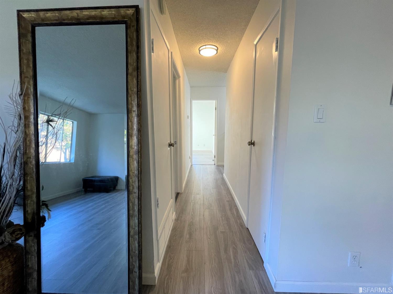 1493 Del Rio Circle, Unit D Concord, CA 94518 - Photo 10 of 23 a view of a hallway with wooden floor and a livingroom