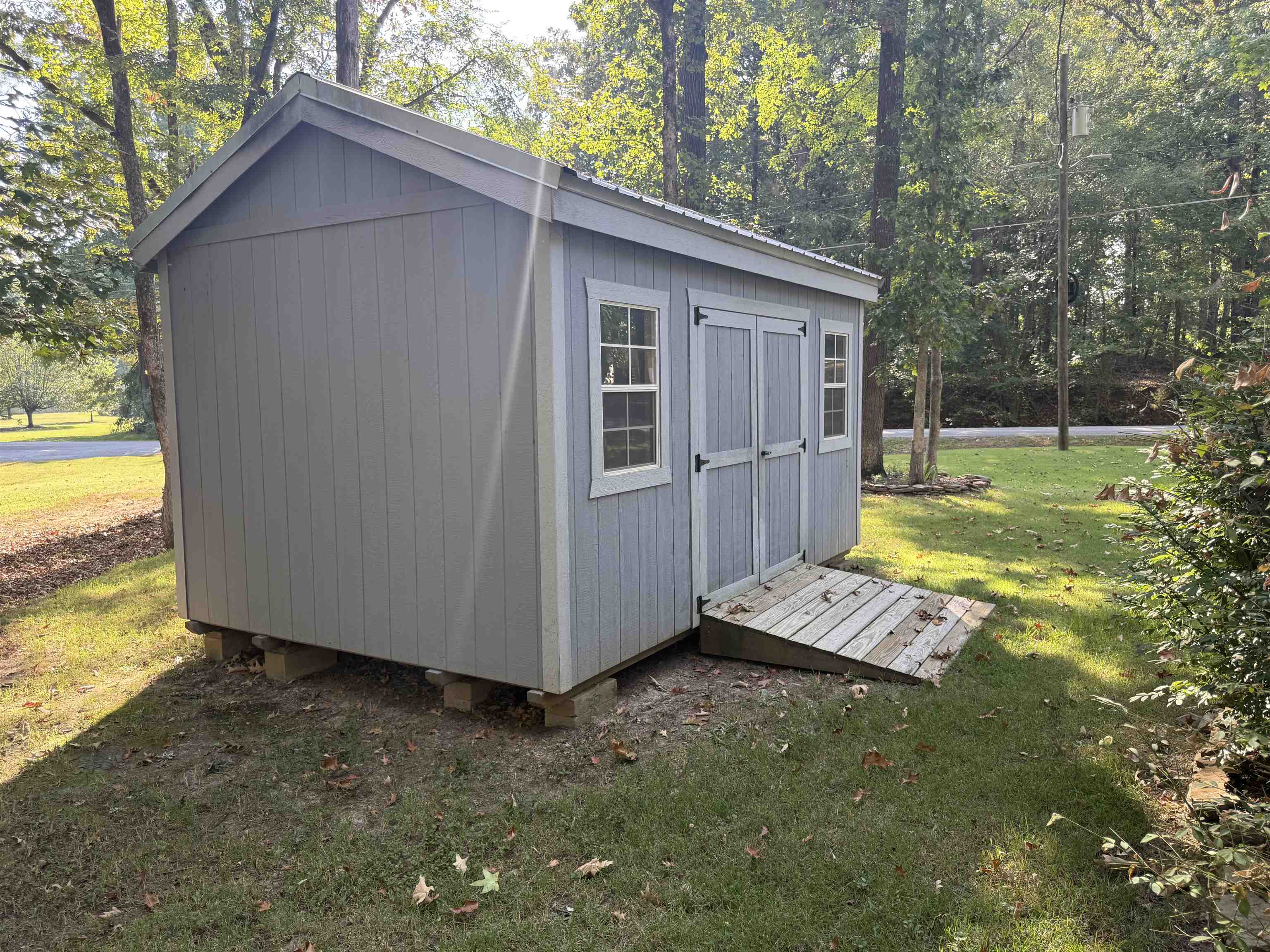 185 Pine Tree Road Moscow, TN 38057 - Photo 30 of 36 Gable roof shed featuring double doors, two window units, and a wood-plank ramp