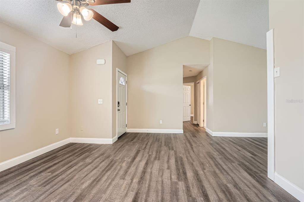 7001 Heath Drive Port Richey, FL 34668 - Photo 3 of 11 wooden floor in an empty room with a window