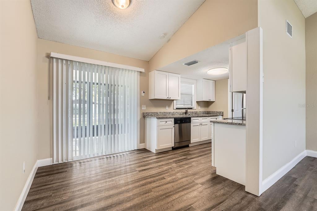 7001 Heath Drive Port Richey, FL 34668 - Photo 4 of 11 a kitchen with a refrigerator a stove top oven a sink and a window