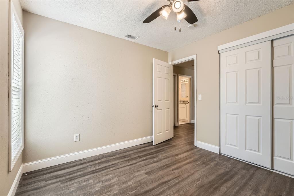 7001 Heath Drive Port Richey, FL 34668 - Photo 9 of 11 a view of an empty room with wooden floor