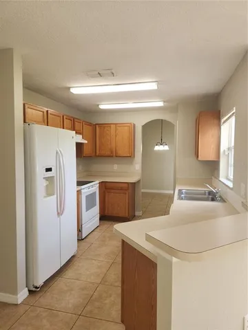 a kitchen with a refrigerator sink and cabinets