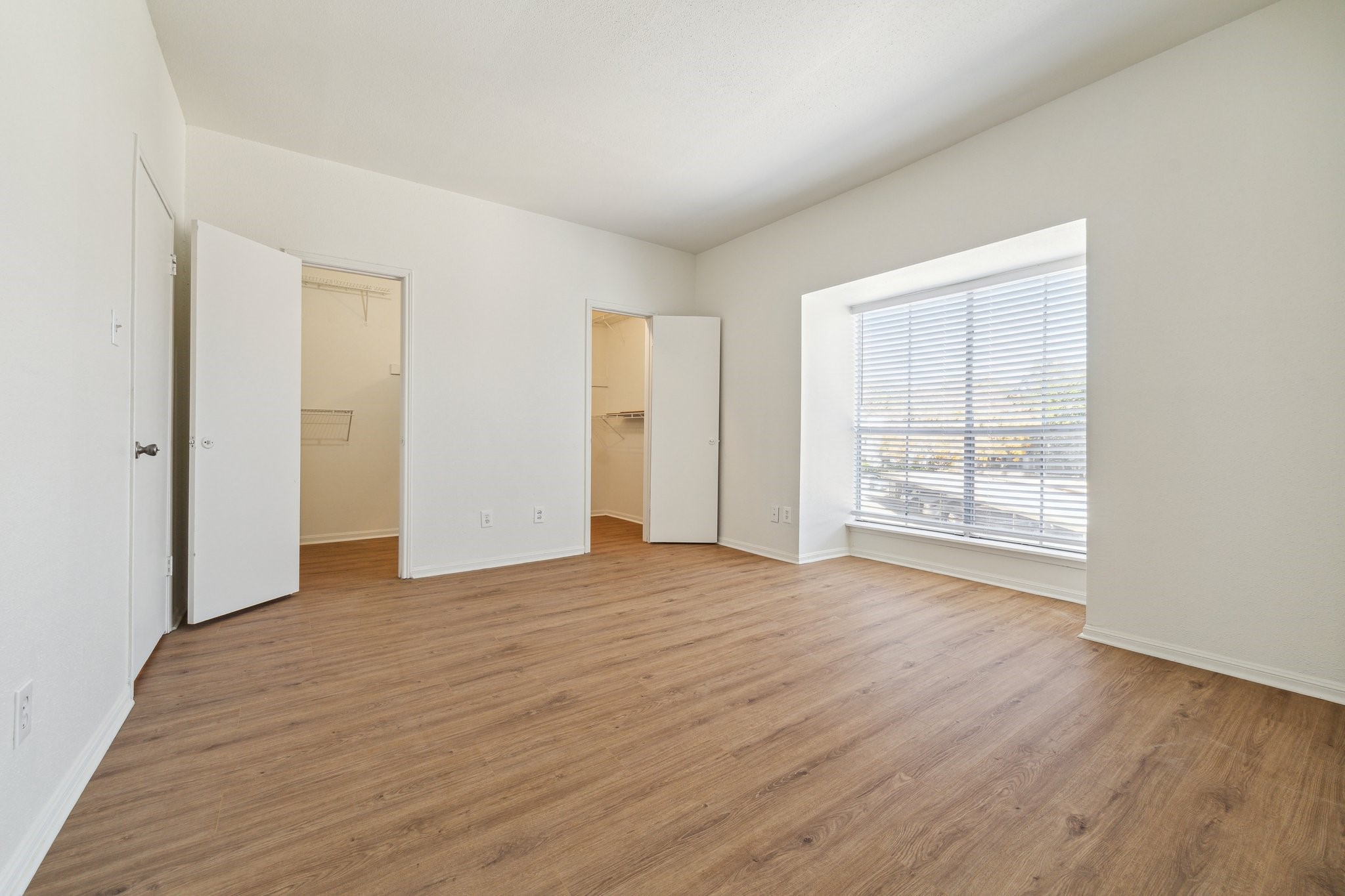 2100 Tanglewilde Street, Unit 514 Houston, TX 77063 - Photo 9 of 22 an empty room with wooden floor and windows