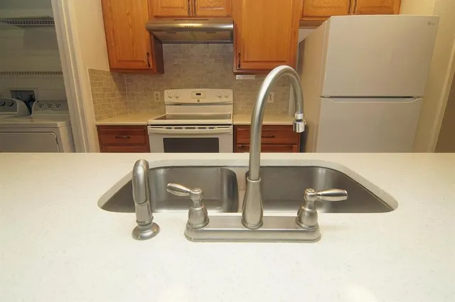 a close view of a sink a counter space and a stove