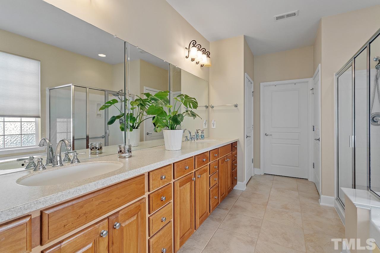 113 Beckingham Loop Cary, NC 27519 - Photo 28 of 46 a spacious bathroom with a double vanity sink and a large mirror