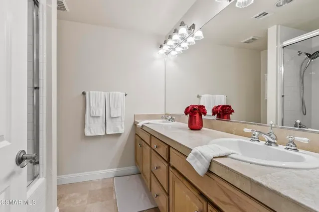 a spacious bathroom with a shower sink and mirror