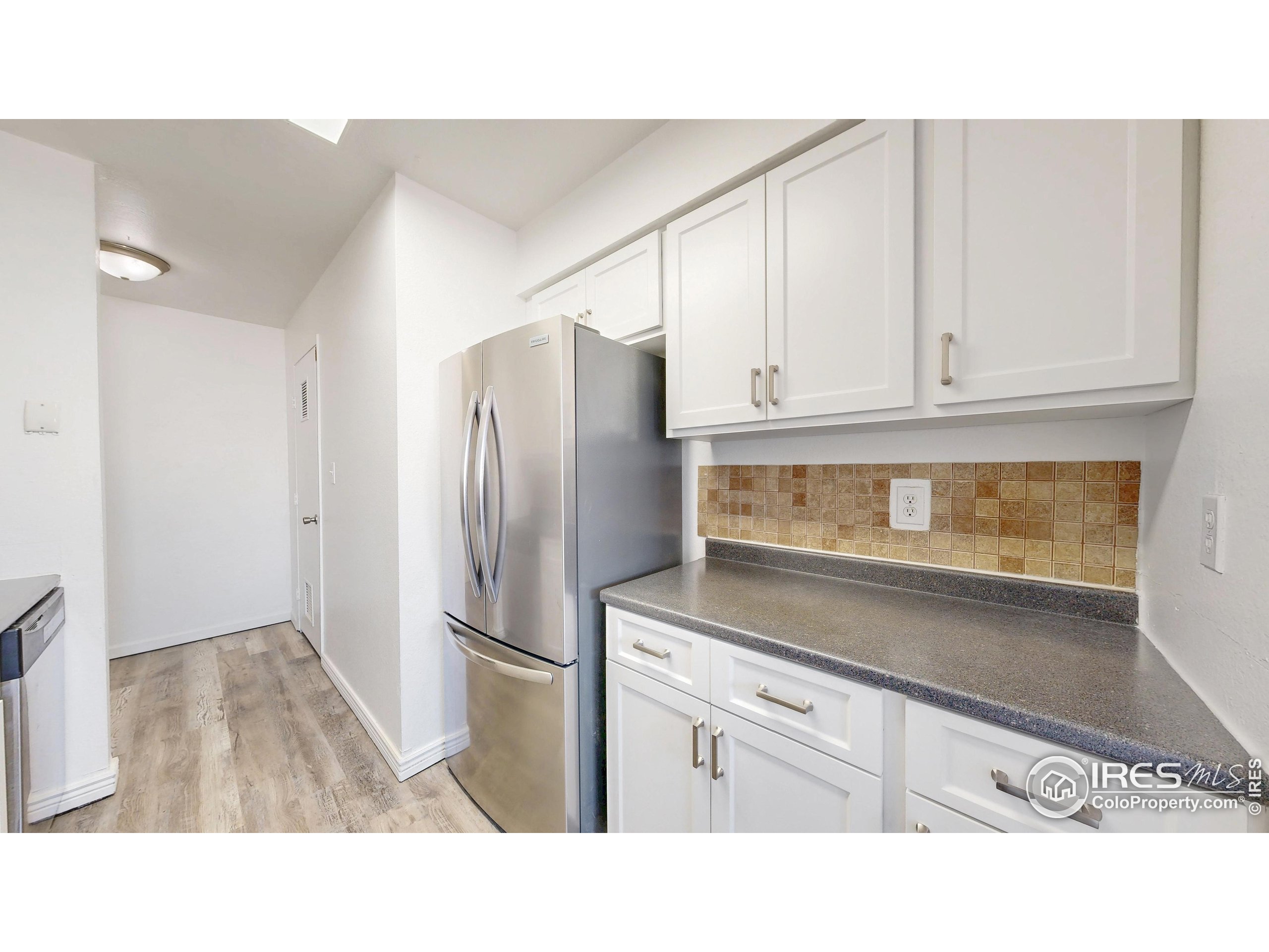 6975 Mariposa Street Denver, CO 80221 - Photo 13 of 34 a kitchen with white cabinets and stainless steel appliances