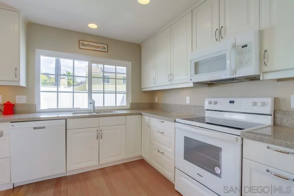 13202 Lingre Avenue Poway, CA 92064 - Photo 34 of 71 a kitchen with granite countertop white cabinets and white appliances