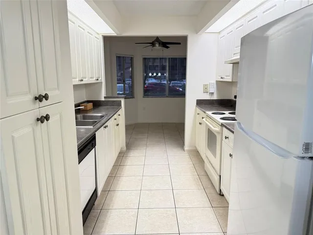 a kitchen with stainless steel appliances granite countertop white cabinets and a stove a refrigerator with white cabinets