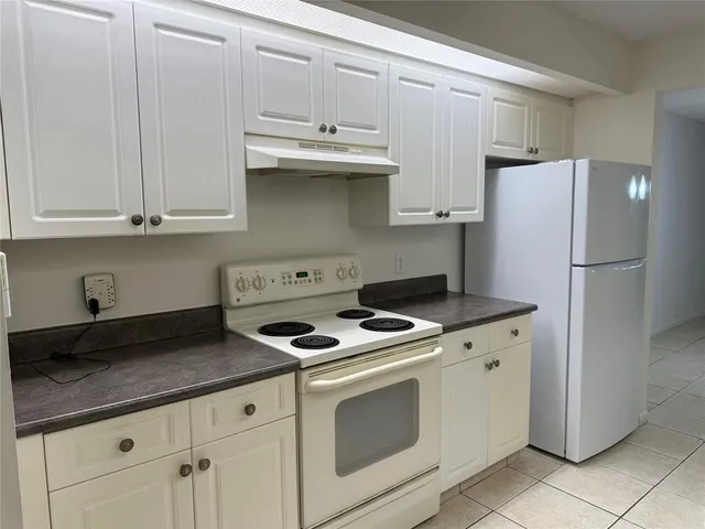 a kitchen with granite countertop white cabinets and a sink