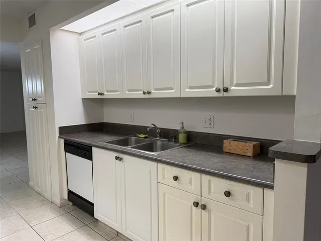 an empty room with windows and cabinet