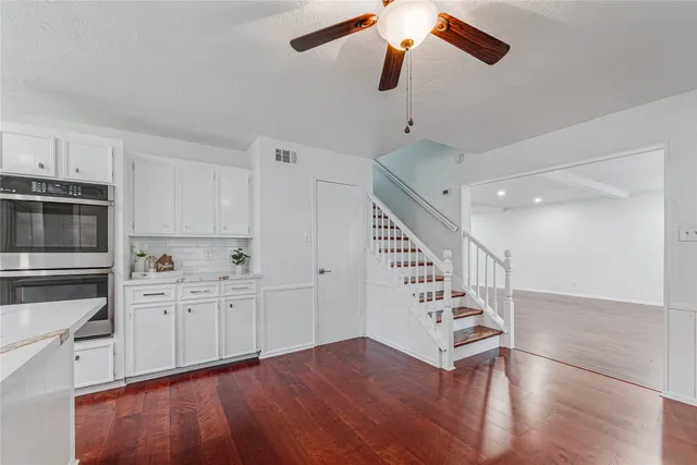 a view of a kitchen with wooden floor and staircase