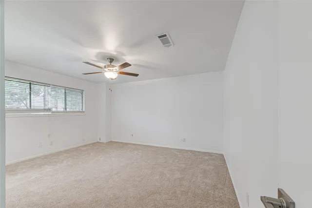 a view of a livingroom with a ceiling fan and window