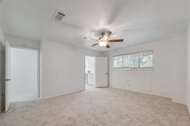 a view of an empty room with a chandelier fan