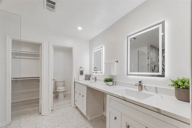 a bathroom with a sink a toilet and a mirror