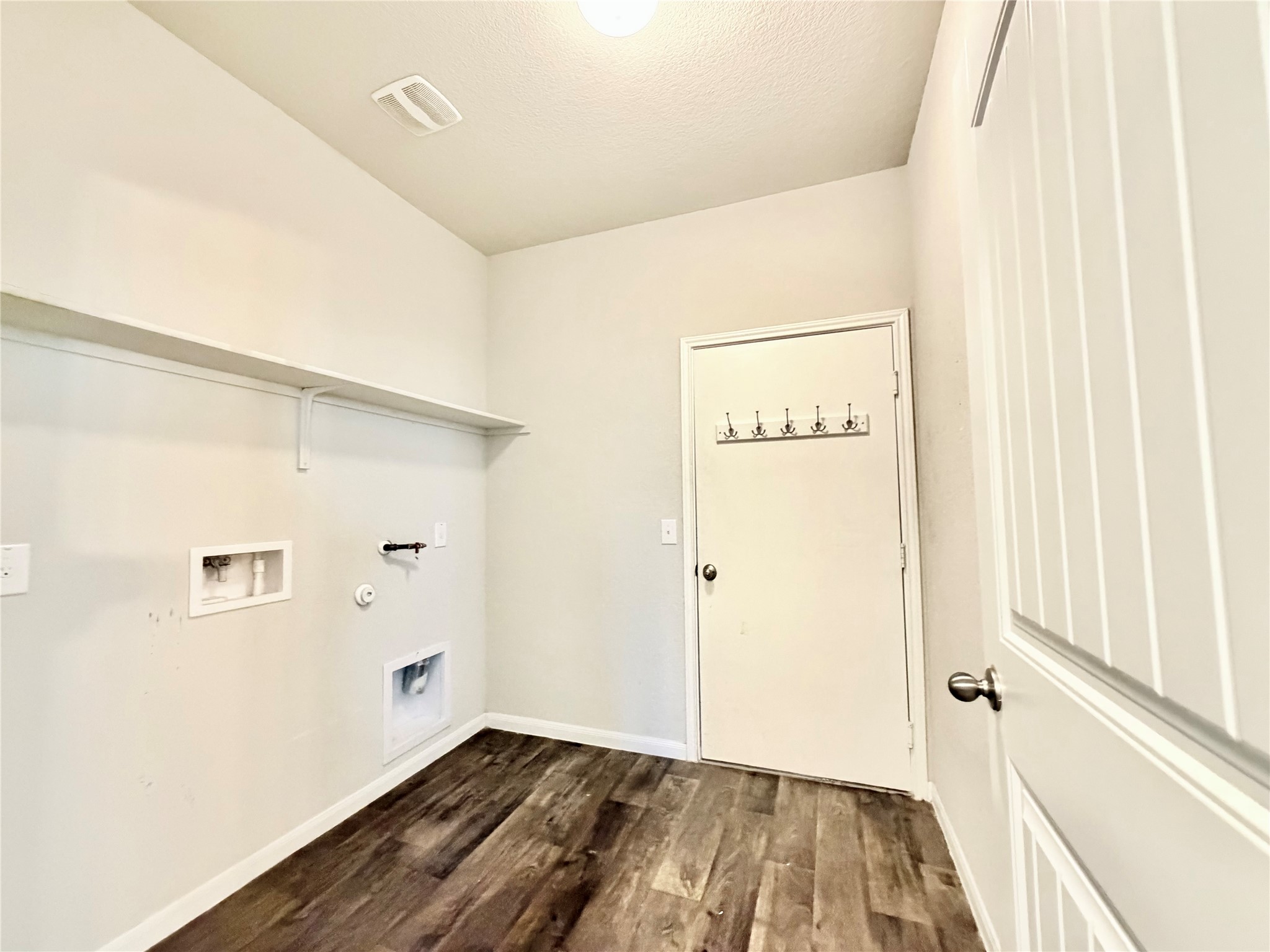 10502 Fulton Avenue Austin, TX 78754 - Photo 13 of 36 Functional laundry space with durable wood-look flooring and convenient overhead shelving.