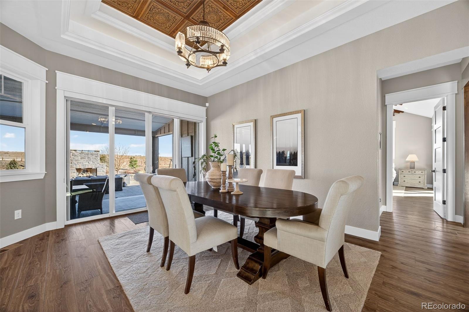 3444 Antelope Ridge Trail Parker, CO 80138 - Photo 16 of 50 a dining room with wooden floor a chandelier a wooden table and chairs