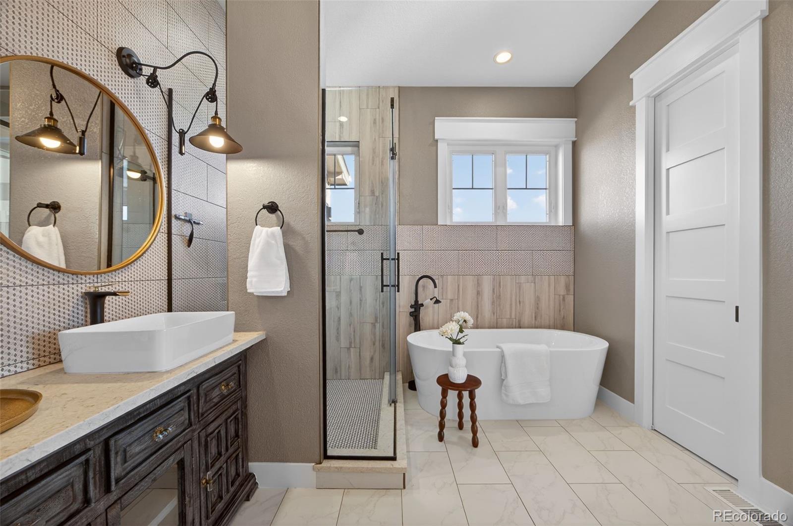 3444 Antelope Ridge Trail Parker, CO 80138 - Photo 23 of 50 a en suite bathroom with a double vanity sink a mirror and a bathtub