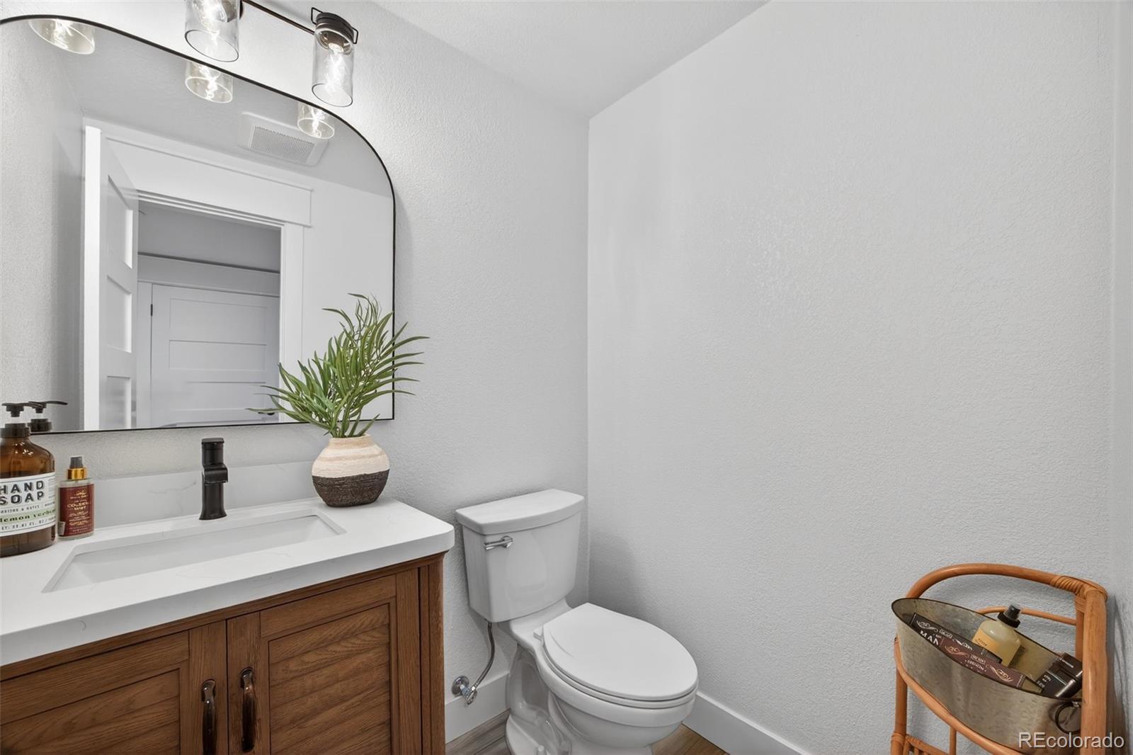 3444 Antelope Ridge Trail Parker, CO 80138 - Photo 34 of 50 a bathroom with a toilet a sink and mirror