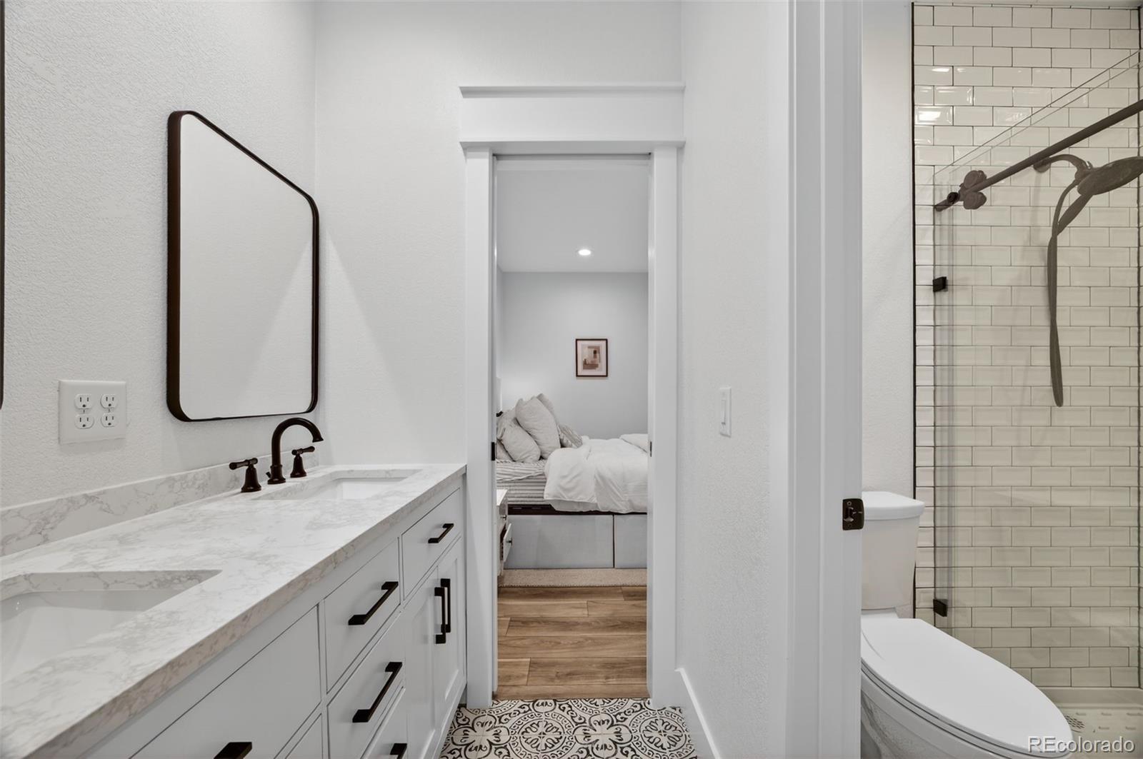 3444 Antelope Ridge Trail Parker, CO 80138 - Photo 36 of 50 a bathroom with a double vanity sink and mirror with toilet