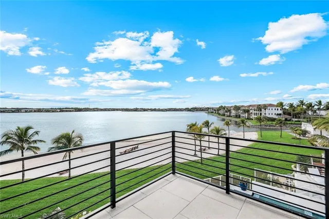 a view of a balcony with floor to ceiling window outdoor seating and ocean view