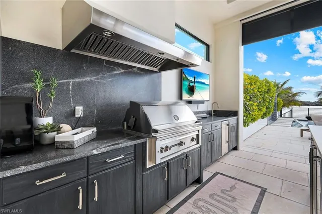 a view of a patio with dining table and chairs with plants and wooden floor