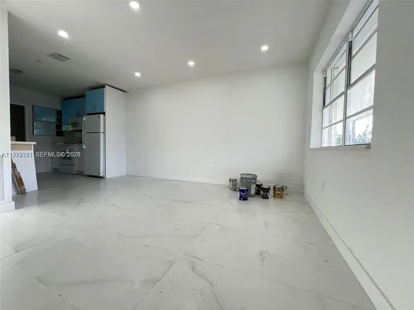 an empty room with furniture and a window